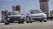 VW Golf eHybrid, Peugeot 308 PHEV, Plug-in-Hybrid, Kompaktklasse, Stadtfahrzeug, Vergleichstest, Parkdeck, Hybridfahrzeug, Volkswagen, Peugeot Zwei Fahrzeuge, ein Peugeot 308 PHEV und ein VW Golf eHybrid, nebeneinander auf einem Parkdeck in der Stadt.