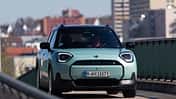Der Dateiname "Mini Aceman SE 49.2kWh-HDS-06.jpg" und die IPTC-Keywords weisen eindeutig auf das Modell Mini Aceman SE mit 49,2 kWh Batterie hin. Das Bild zeigt einen türkisfarbenen Mini Aceman SE in Frontansicht auf einer Straße im urbanen Umfeld. Die visuelle Analyse bestätigt ein modernes Elektroauto mit typischen Mini-Designmerkmalen.