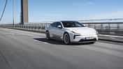 Polestar 5 Dual Motor auf einer Brücke, fahrend von links nach rechts, in Seitenansicht.