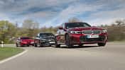 Drei Limousinen-Modelle Alfa Romeo Giulia 2.2, BMW 320d und Mercedes C 220d fahren auf einer Landstraße.