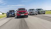 Vier aktuelle SUV-Modelle (Citroën C5 Aircross Hybrid, Mazda CX-5, Kia Sportage, Ford Kuga) fahren nebeneinander auf einer Landstraße. Die Fahrzeuge sind frontal und dynamisch im Verband aufgenommen, alle Modelle sind klar erkennbar.