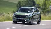 Ford Kuga 1,5l EcoBoost, Ford Kuga, SUV, EcoBoost, Ford, Kompakt-SUV, Benzinmotor, Frontansicht, Straßenfahrt, Automobil Ford Kuga 1,5l EcoBoost SUV in Grün auf Landstraße, Frontansicht, fahrend, Sommerlandschaft im Hintergrund.